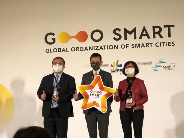 台北市政府副秘書長李得全（中）頒發2022全球智慧城市聯盟GO+SMART特別獎智慧城市人本獎給新北市社會局副局長許秀能（右）左為新北市政府資訊中心主任陳富添
